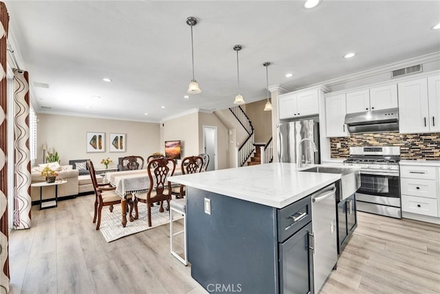 2517 Macbeth Ave, Corona, CA 92882 - kitchen featuring stainless steel appliances, under cabinet range hood, white cabinets, gray cabinetry, and ornamental molding