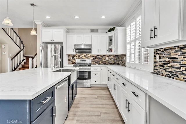 2517 Macbeth Ave, Corona, CA 92882 - kitchen with stainless steel appliances, white cabinets, hanging light fixtures, crown molding, and light stone counters