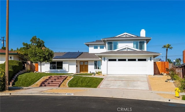 5662 Trail View Pl, Yorba Linda, CA 92886 - view of front facade with driveway, solar panels, stucco siding, and a chimney