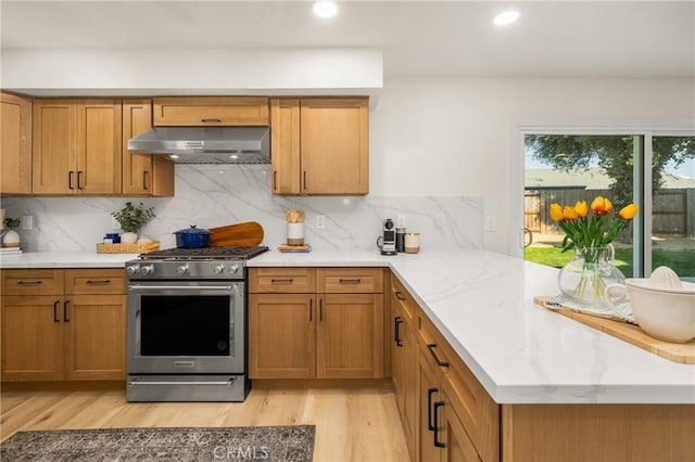 5662 Trail View Pl, Yorba Linda, CA 92886 - kitchen featuring under cabinet range hood, stainless steel gas range, a peninsula, light wood-type flooring, and brown cabinets