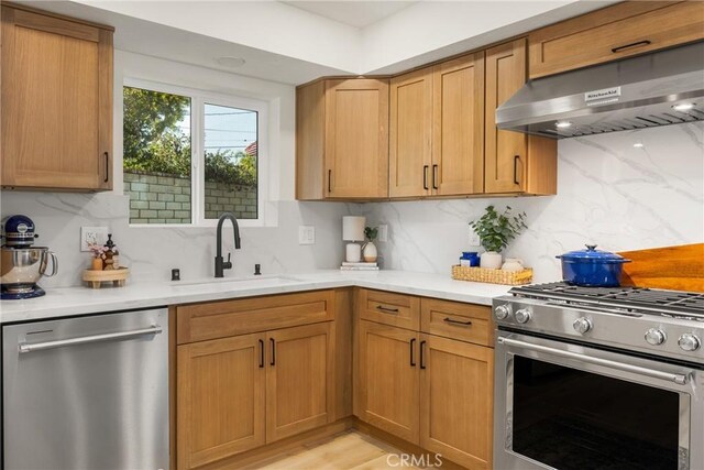 5662 Trail View Pl, Yorba Linda, CA 92886 - kitchen with stainless steel appliances, under cabinet range hood, a sink, and backsplash