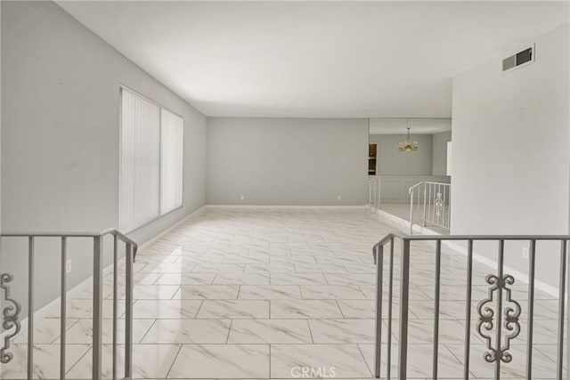 1403 W Westmont Dr, Anaheim, CA 92801 - unfurnished room featuring a chandelier, marble finish floors, and baseboards