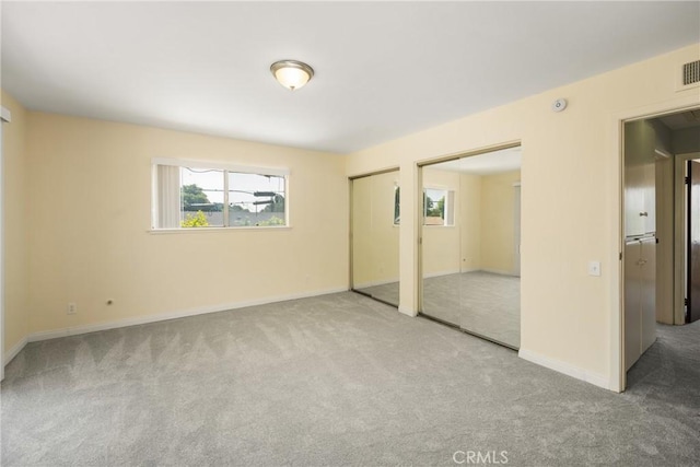 1403 W Westmont Dr, Anaheim, CA 92801 - unfurnished bedroom with two closets, carpet flooring, and baseboards