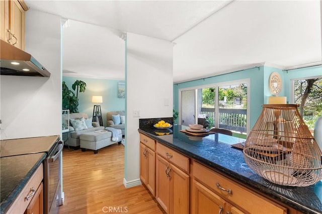 810 Camino Real Unit 104, Redondo Beach, CA 90277 - kitchen with stainless steel electric stove, healthy amount of natural light, light wood-style flooring, and dark stone counters