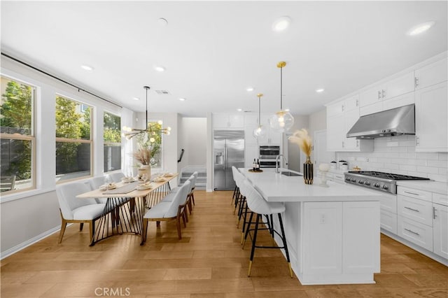 10 Veraz Rd, Rancho Mission Viejo, CA 92694 - kitchen with wall chimney range hood, stainless steel appliances, a sink, light countertops, and decorative backsplash