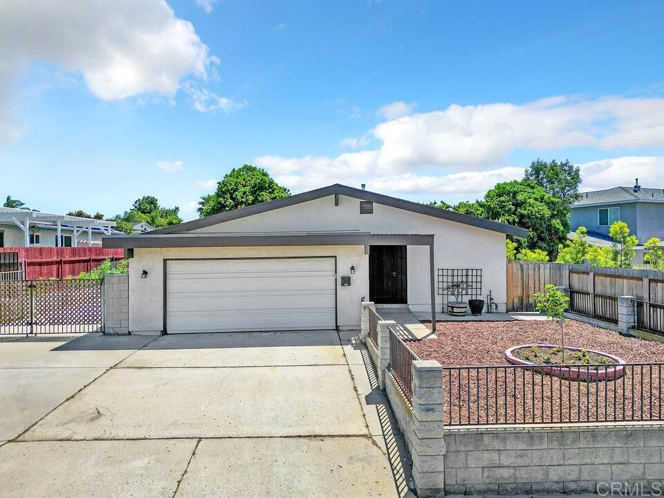 9207 Massot Ave, Santee, CA 92071 - ranch-style home with driveway, fence, a garage, and stucco siding