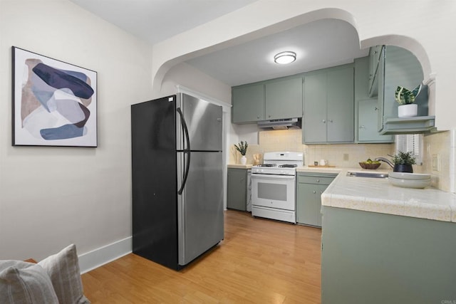3536 Park Villa, San Diego, CA 92104 - kitchen featuring freestanding refrigerator, white gas stove, under cabinet range hood, green cabinets, and a sink