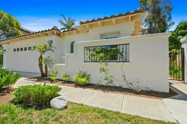 1736 Blackbird Cir, Carlsbad, CA 92011 - mediterranean / spanish house with an attached garage, a tile roof, and stucco siding