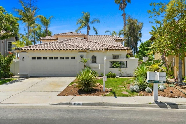 1736 Blackbird Cir, Carlsbad, CA 92011 - mediterranean / spanish home featuring a tiled roof, an attached garage, stucco siding, concrete driveway, and a gate