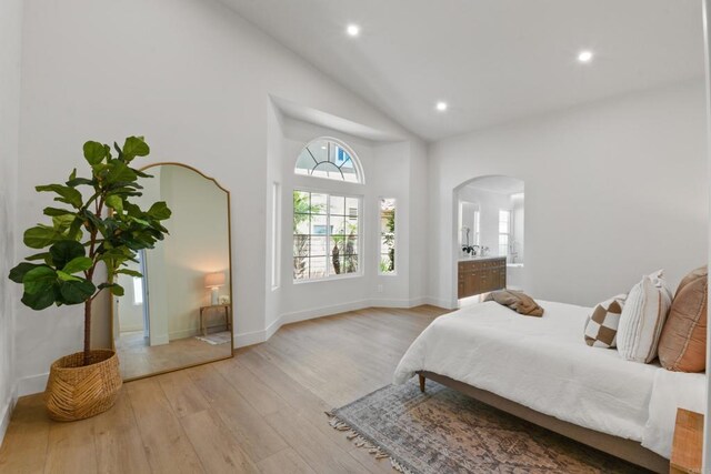 1736 Blackbird Cir, Carlsbad, CA 92011 - bedroom featuring arched walkways, wood finished floors, recessed lighting, high vaulted ceiling, and ensuite bathroom