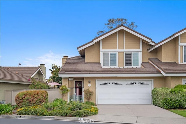 9 Northgrove Unit 11, Irvine, CA 92604 - view of front of home featuring stucco siding, concrete driveway, a garage, and fence