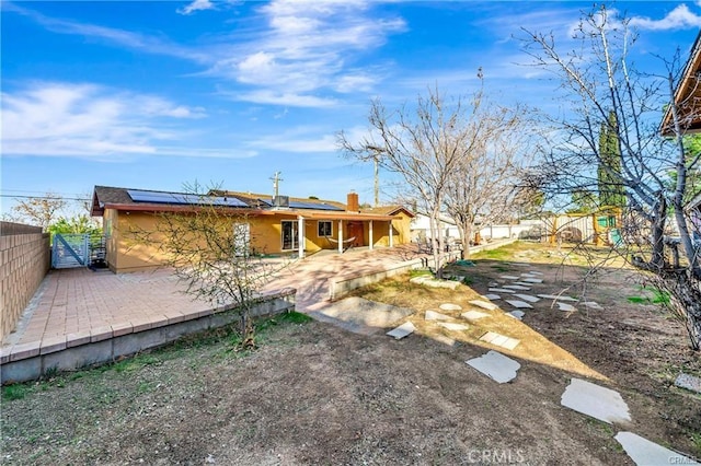 5306 W W Ave M4, Lancaster, CA 93536 - back of property featuring a patio, a fenced backyard, solar panels, and a gate