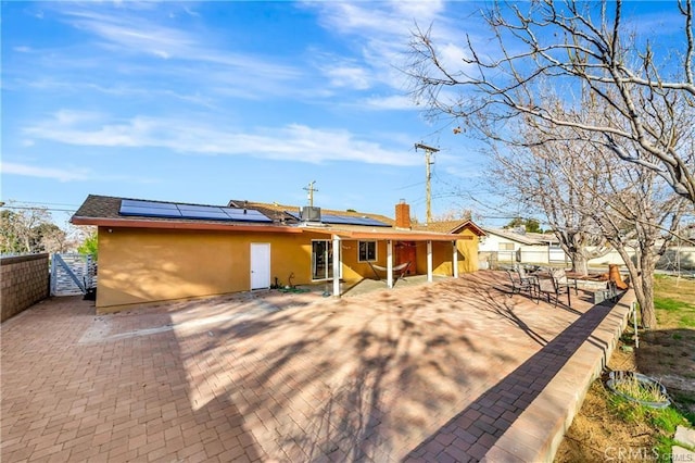 5306 W W Ave M4, Lancaster, CA 93536 - back of property featuring stucco siding, a patio area, a fenced backyard, and roof mounted solar panels