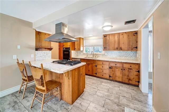 5306 W W Ave M4, Lancaster, CA 93536 - kitchen featuring island range hood, a sink, brown cabinetry, and decorative backsplash