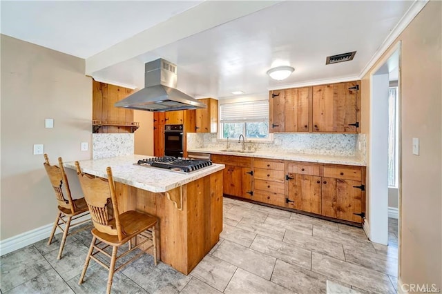 5306 W W Ave M4, Lancaster, CA 93536 - kitchen with island exhaust hood, brown cabinets, stainless steel gas stovetop, and decorative backsplash