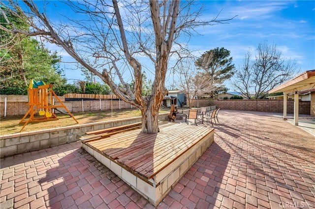 5306 W W Ave M4, Lancaster, CA 93536 - deck featuring a fenced backyard, a patio, and a playground