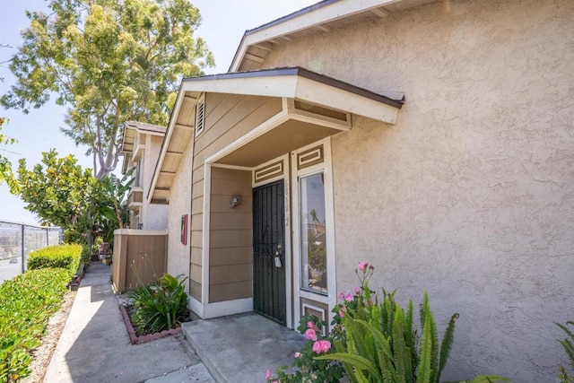 6860 Panamint Row Unit 2, San Diego, CA 92139 - doorway to property featuring fence and stucco siding