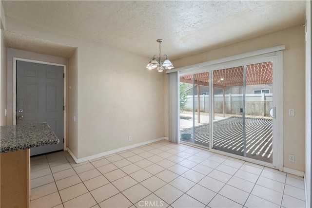 14889 Hartford Ln, Helendale, CA 92342 - unfurnished dining area featuring a textured ceiling, a chandelier, light tile patterned flooring, and baseboards
