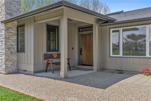 property entrance with crawl space, a chimney, and board and batten siding