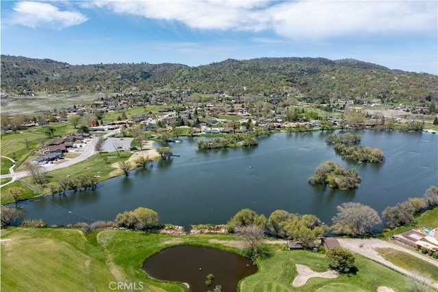 aerial view of property and surrounding area featuring a local golf course, nearby suburban area, and a water and mountain view