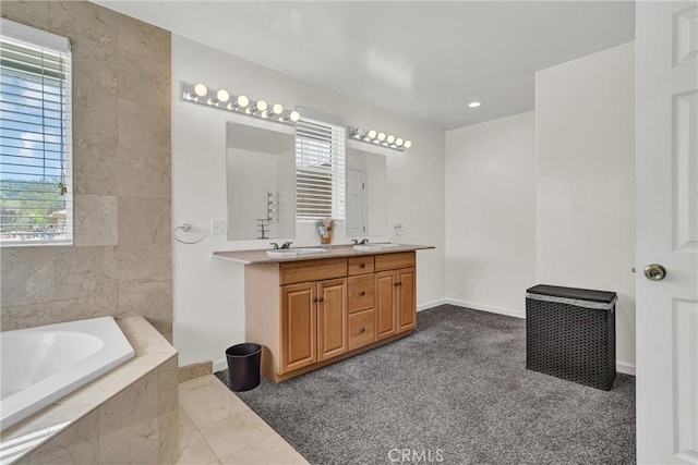 bathroom featuring a bath, double vanity, and baseboards