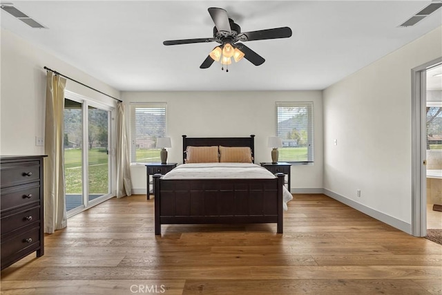bedroom featuring access to exterior, multiple windows, and light wood finished floors