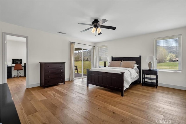 bedroom with access to exterior, an office area, hardwood / wood-style flooring, baseboards, and a ceiling fan