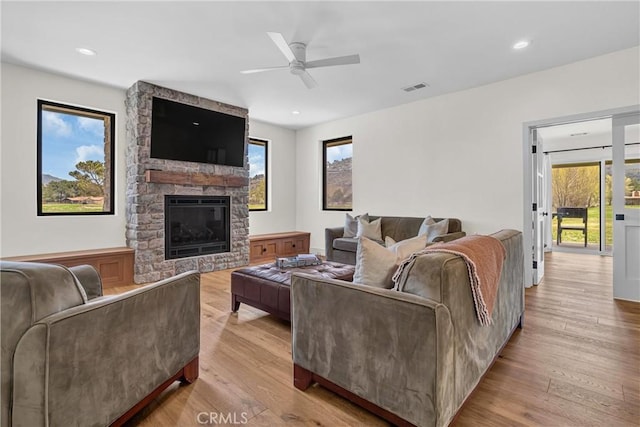 living area with a ceiling fan, wood finished floors, plenty of natural light, a fireplace, and recessed lighting
