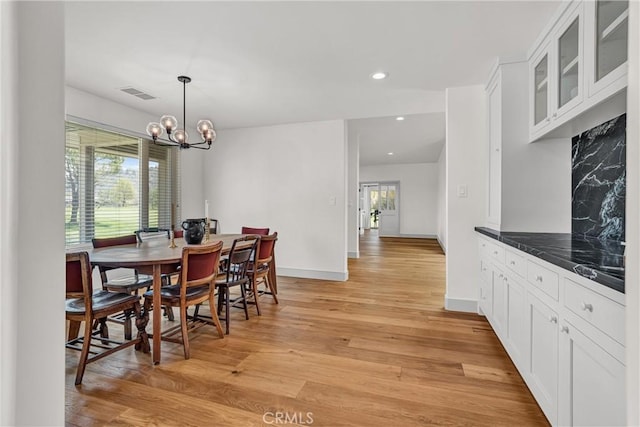 dining area with light wood-style floors, a chandelier, baseboards, and recessed lighting