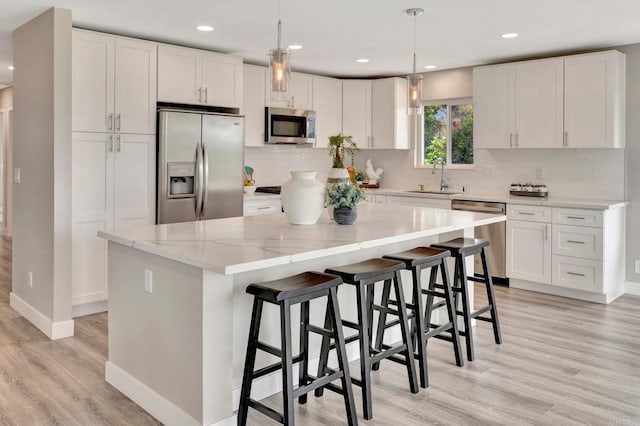 1055 Via Lomita, Escondido, CA 92027 - kitchen with appliances with stainless steel finishes, a sink, baseboards, white cabinetry, and light wood-type flooring
