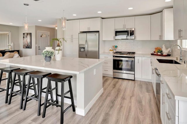 1055 Via Lomita, Escondido, CA 92027 - kitchen with stainless steel appliances, a sink, light wood-type flooring, a kitchen island, and recessed lighting