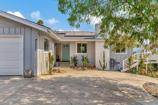 1055 Via Lomita, Escondido, CA 92027 - ranch-style home featuring board and batten siding, a shingled roof, an attached garage, and solar panels