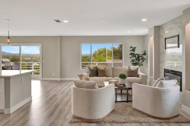 1055 Via Lomita, Escondido, CA 92027 - living area featuring healthy amount of natural light, a fireplace, light wood finished floors, recessed lighting, and baseboards