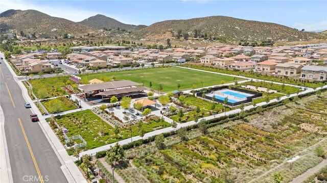 aerial view of property and surrounding area featuring nearby suburban area and a mountainous background