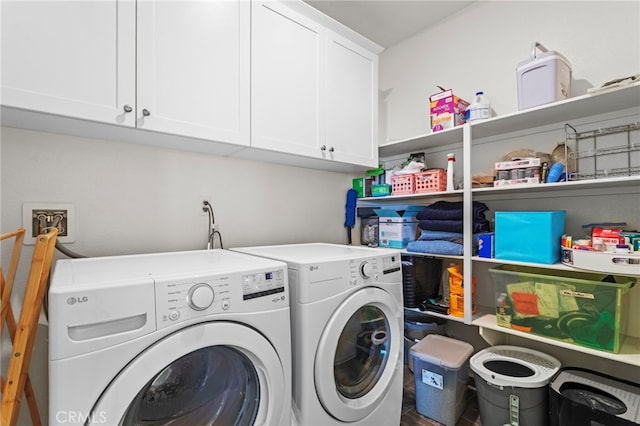 clothes washing area with washing machine and dryer and cabinet space