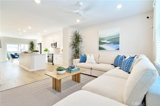 living room with light wood finished floors, recessed lighting, and a ceiling fan
