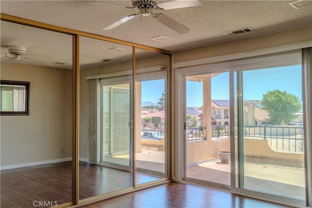 entryway featuring ceiling fan, wood finished floors, a textured ceiling, and baseboards