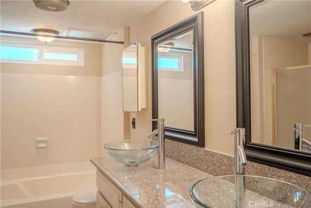 full bathroom featuring healthy amount of natural light, vanity, toilet, and bathtub / shower combination