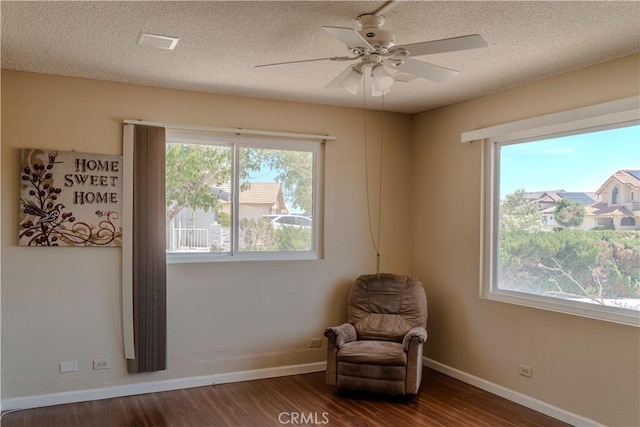 unfurnished room with dark wood-type flooring, a textured ceiling, ceiling fan, and baseboards