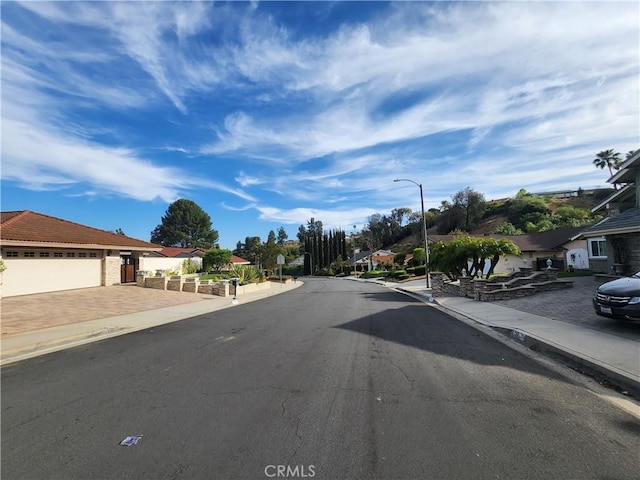 1428 Blenbury Dr, Diamond Bar, CA 91765 - view of asphalt road with street lights, a residential view, sidewalks, and curbs