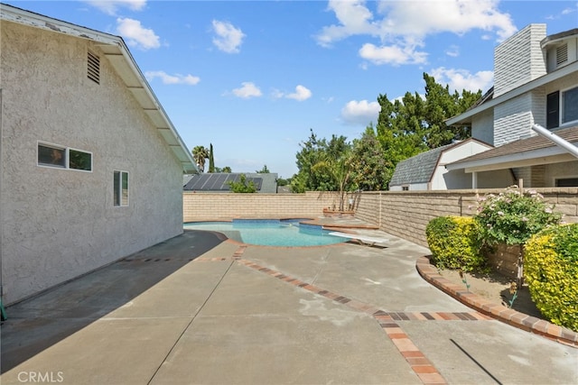 view of pool featuring a patio, a fenced backyard, and a diving board