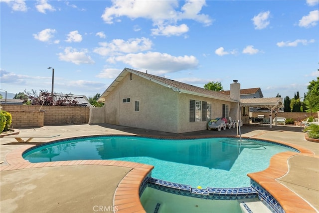 view of swimming pool with a patio area, a pool with connected hot tub, and a fenced backyard