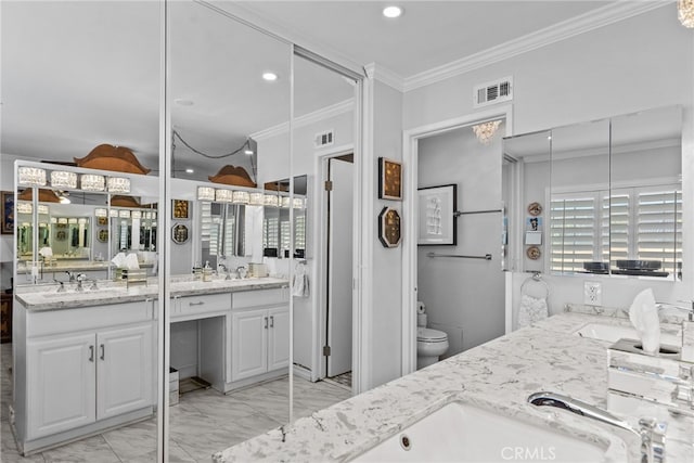 bathroom with marble look tiles, ornamental molding, double vanity, toilet, and recessed lighting