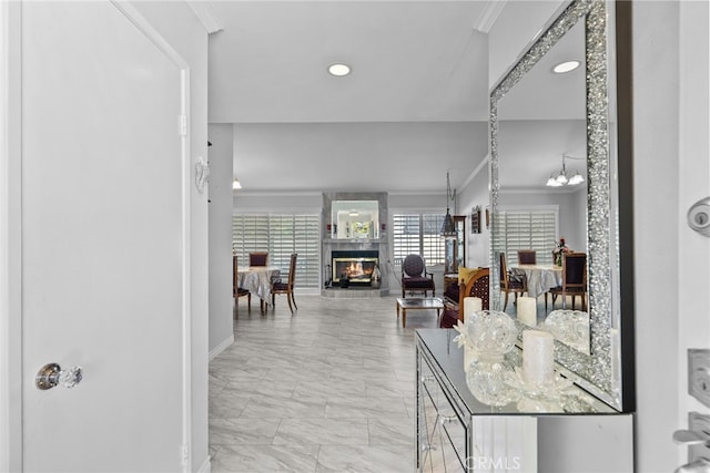 hallway with ornamental molding, light marble finish floors, baseboards, and recessed lighting