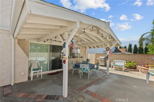 view of patio with grilling area, fence, and outdoor dining area