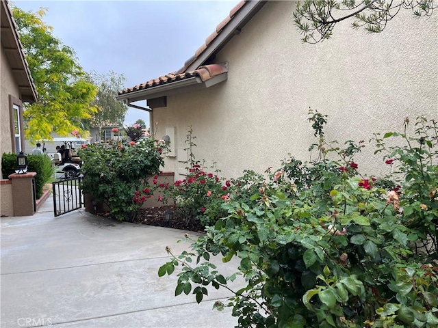 1321 Cypress Point Dr, Banning, CA 92220 - view of side of home with stucco siding and a tiled roof