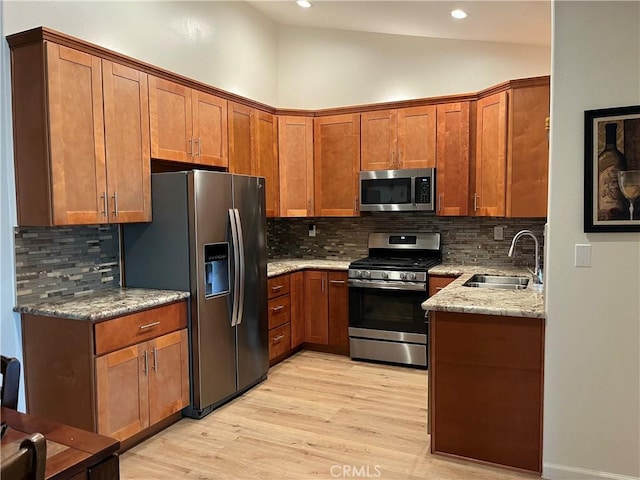 1321 Cypress Point Dr, Banning, CA 92220 - kitchen featuring stainless steel appliances, a sink, light wood-type flooring, light stone countertops, and backsplash