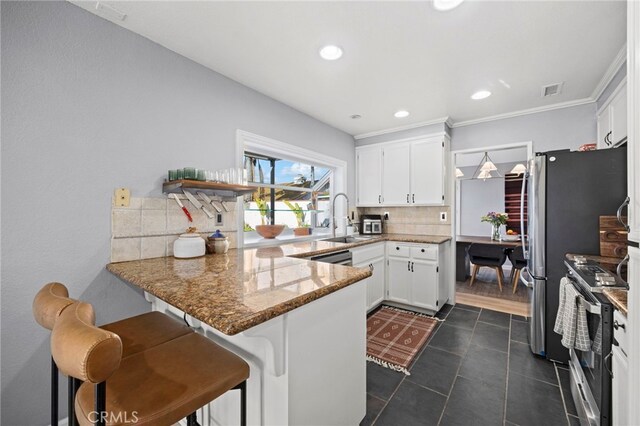 3388 Tonopah St, Oceanside, CA 92054 - kitchen featuring a sink, a peninsula, stainless steel range with electric stovetop, backsplash, and white cabinets