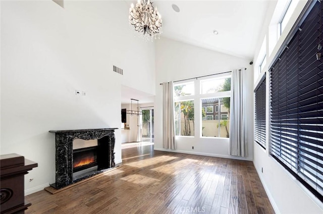 127 Lessay, Newport Coast, CA 92657 - unfurnished living room featuring a chandelier, a fireplace, wood finished floors, high vaulted ceiling, and baseboards