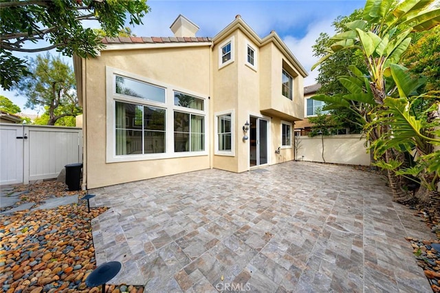 127 Lessay, Newport Coast, CA 92657 - rear view of property featuring stucco siding, a fenced backyard, a gate, and a patio area